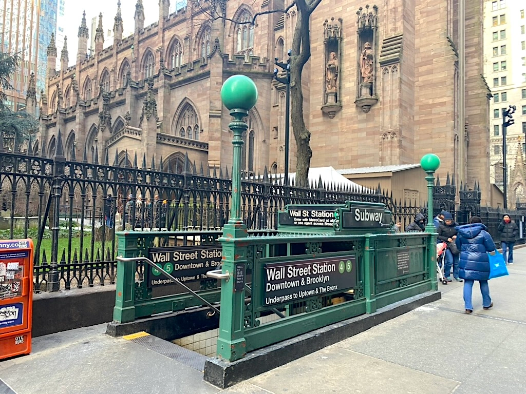 A New York City subway entrance with commuters going down the stairs
