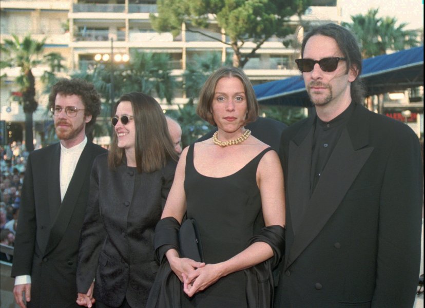 A celebrity walking the Cannes Film Festival red carpet in the 1990s wearing a couture gown, photographers lining the steps