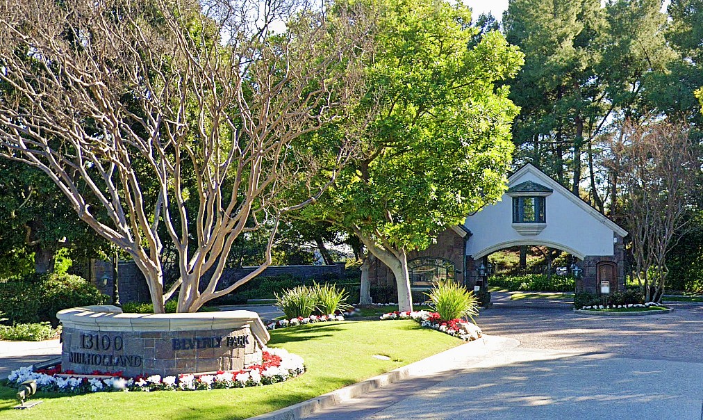 A gated home in Beverly Hills with tall hedges and a security gate facing the street