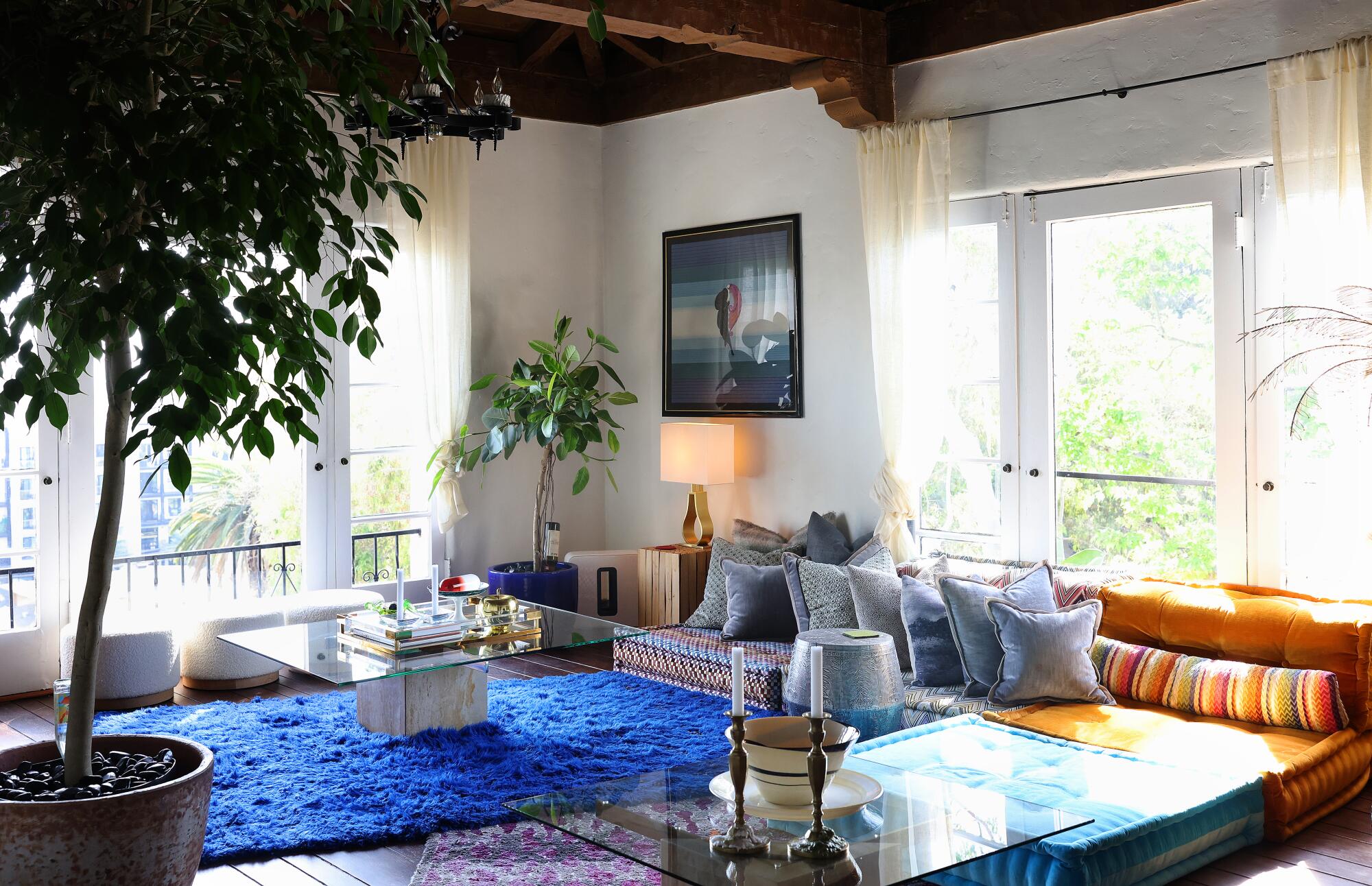 A modern Los Angeles living room with a large neutral area rug anchored under the sofa and coffee table, creating a spacious, high-end feel