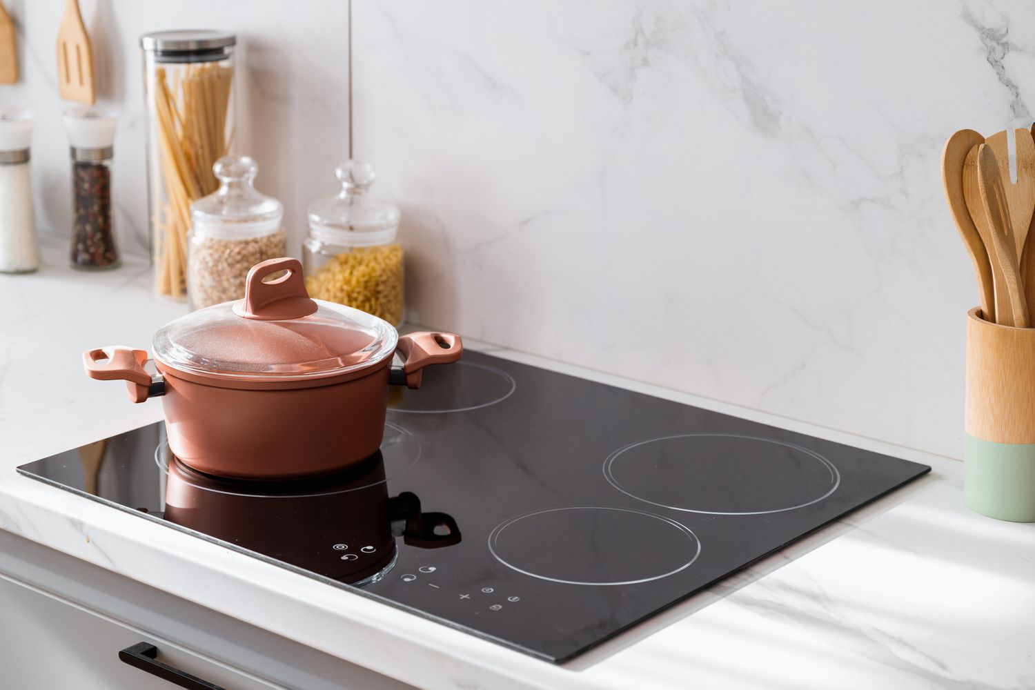 A modern kitchen with an induction cooktop built into a countertop, showing a sleek electric cooking surface