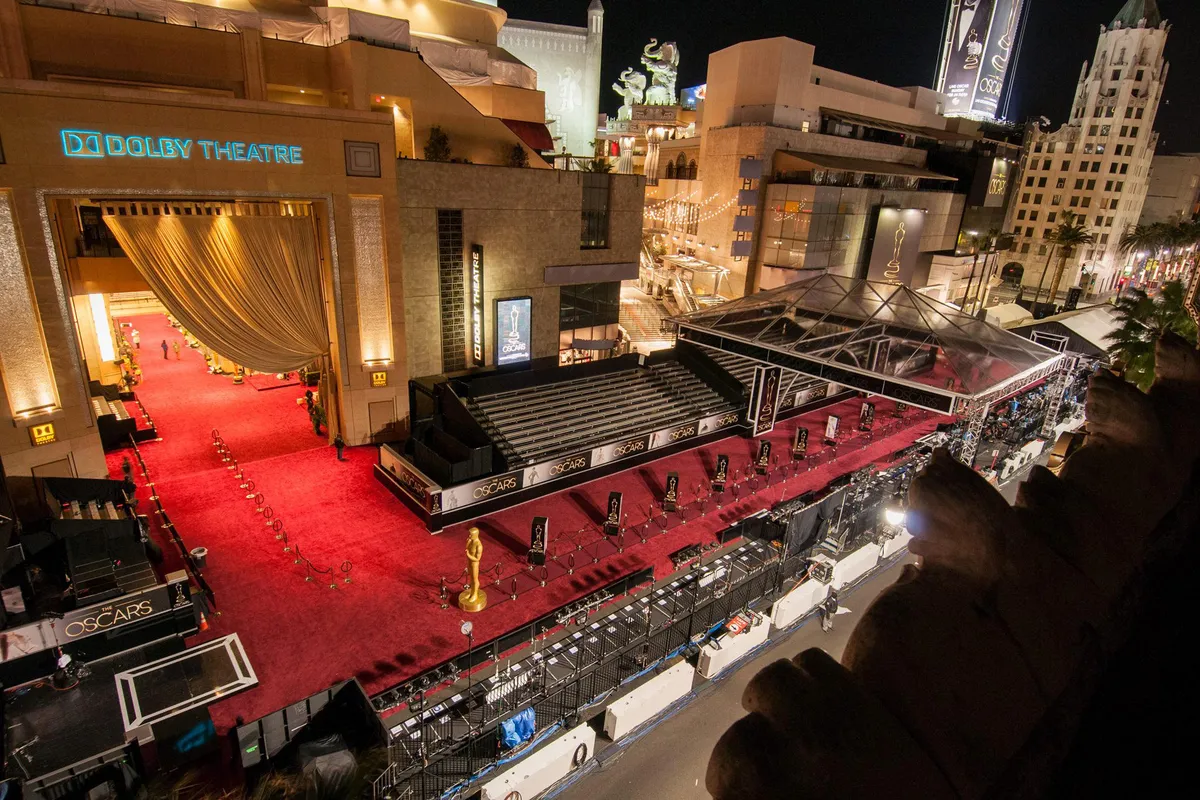 A red carpet scene outside the Dolby Theatre in Hollywood with photographers and stanchions set up ahead of an awards ceremony
