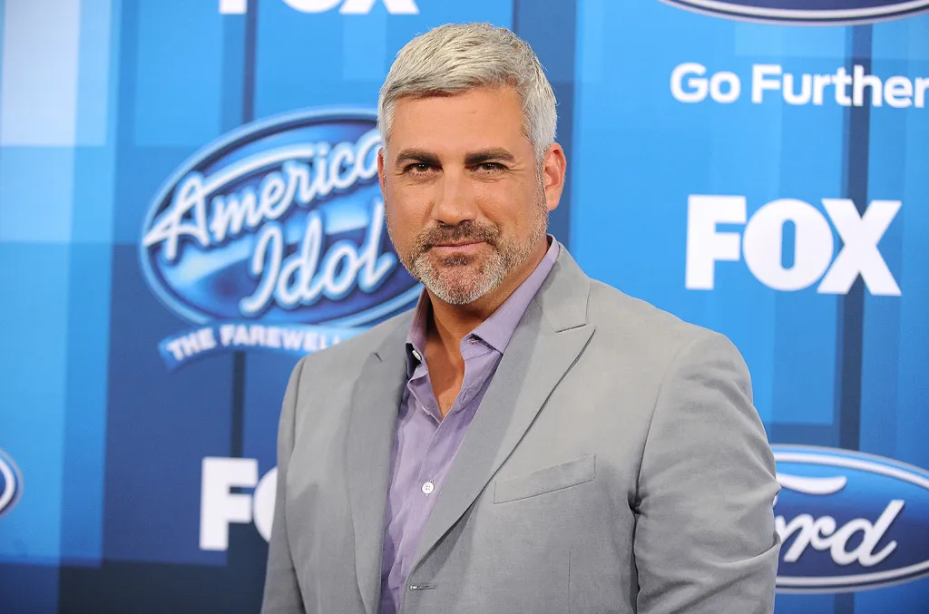 A televised winner interview setup with bright stage lighting and a host speaking to a newly crowned performer