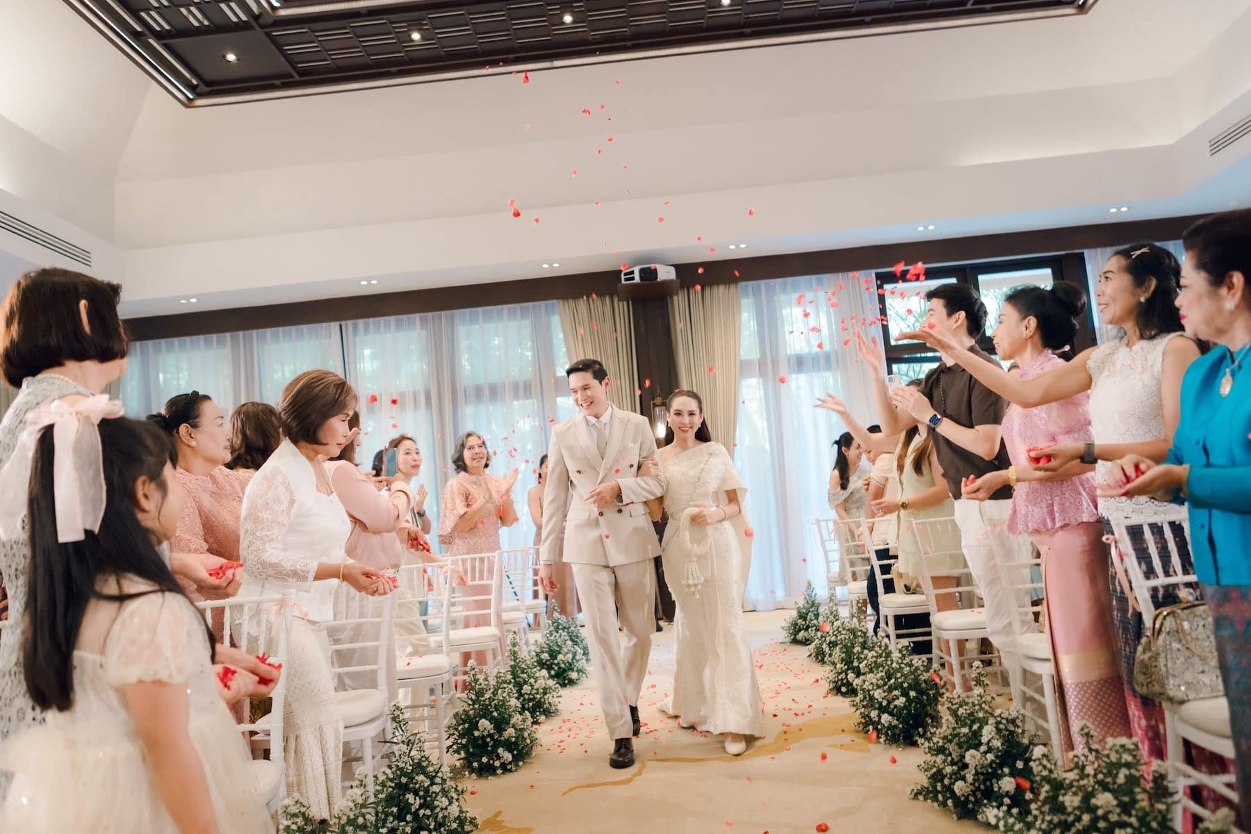 A wedding ceremony setup with floral decor and warm lighting, photographed in a formal venue