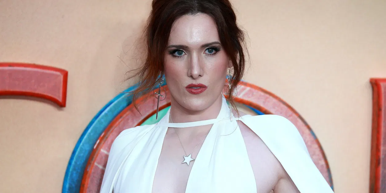 Abigail Thorn poses on a red carpet at an entertainment industry event, facing photographers as cameras flash.