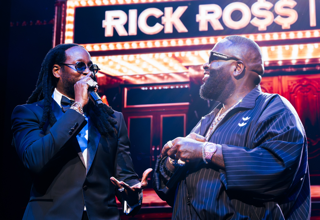 Bigga Rankin posing for a backstage photo with a major hip-hop artist at a concert venue, both smiling for the camera in a candid moment