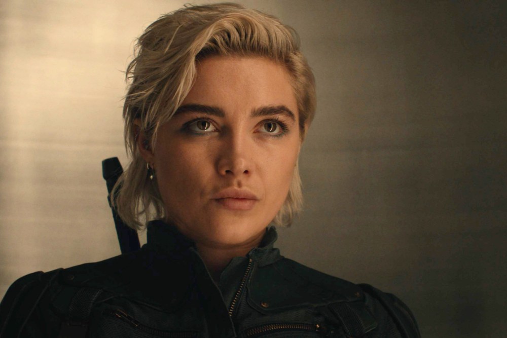 Florence Pugh posing at a 2026 red carpet event, photographed in a sleek, modern evening look with soft glam makeup, entertainment photography style