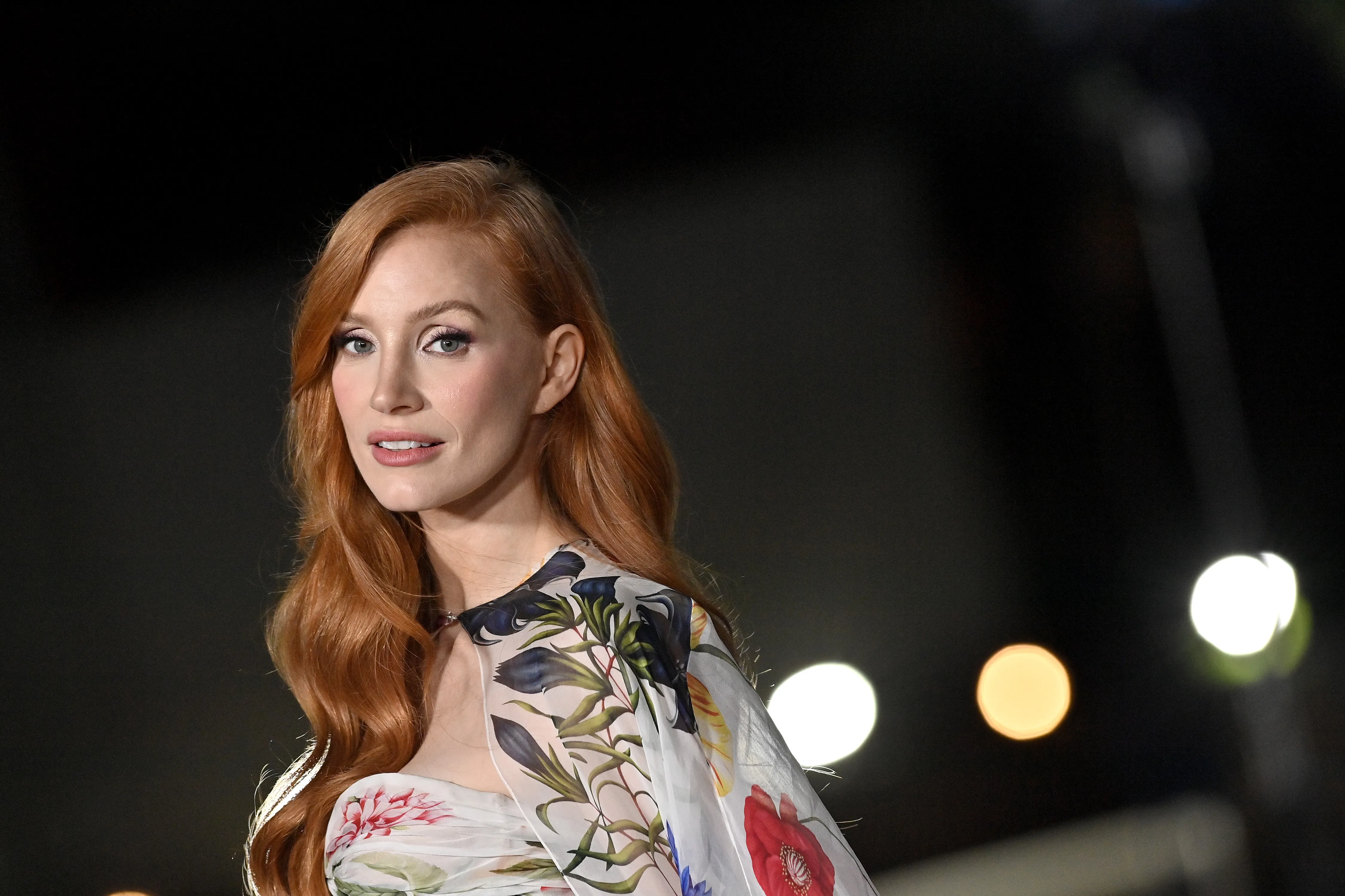 Jessica Chastain posing for photographers outside a Broadway theater.