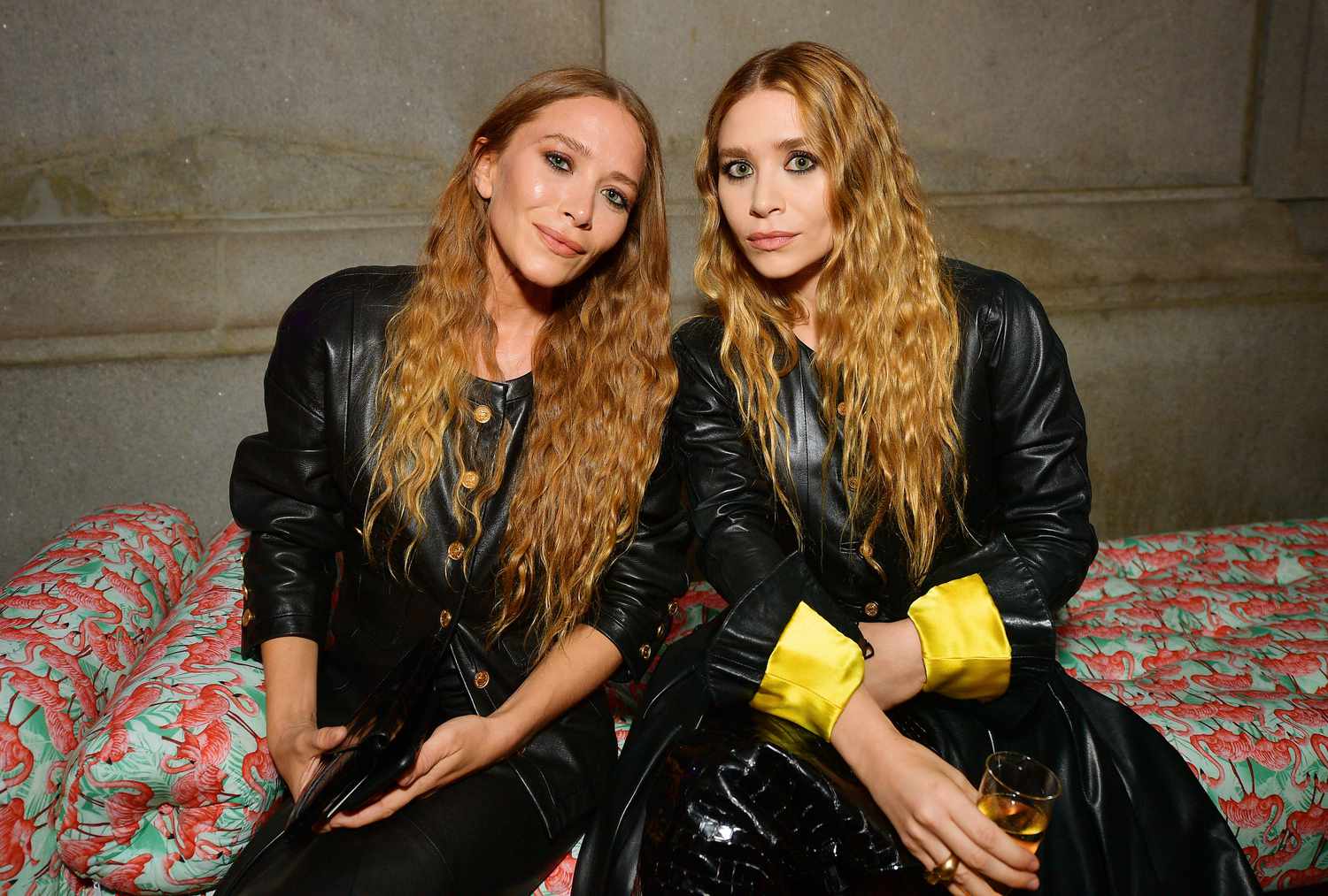 Mary-Kate Olsen and Ashley Olsen arriving at a fashion industry event in elegant, minimalist outfits, photographed outside a venue at night