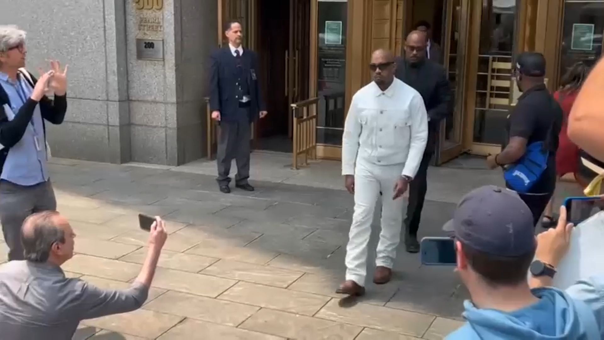 Sean “Diddy” Combs seated in a courtroom during legal proceedings, with attorneys nearby