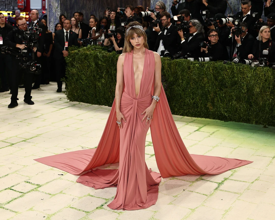 Suki Waterhouse attending a public event in a stylish evening outfit, photographed under bright event lighting