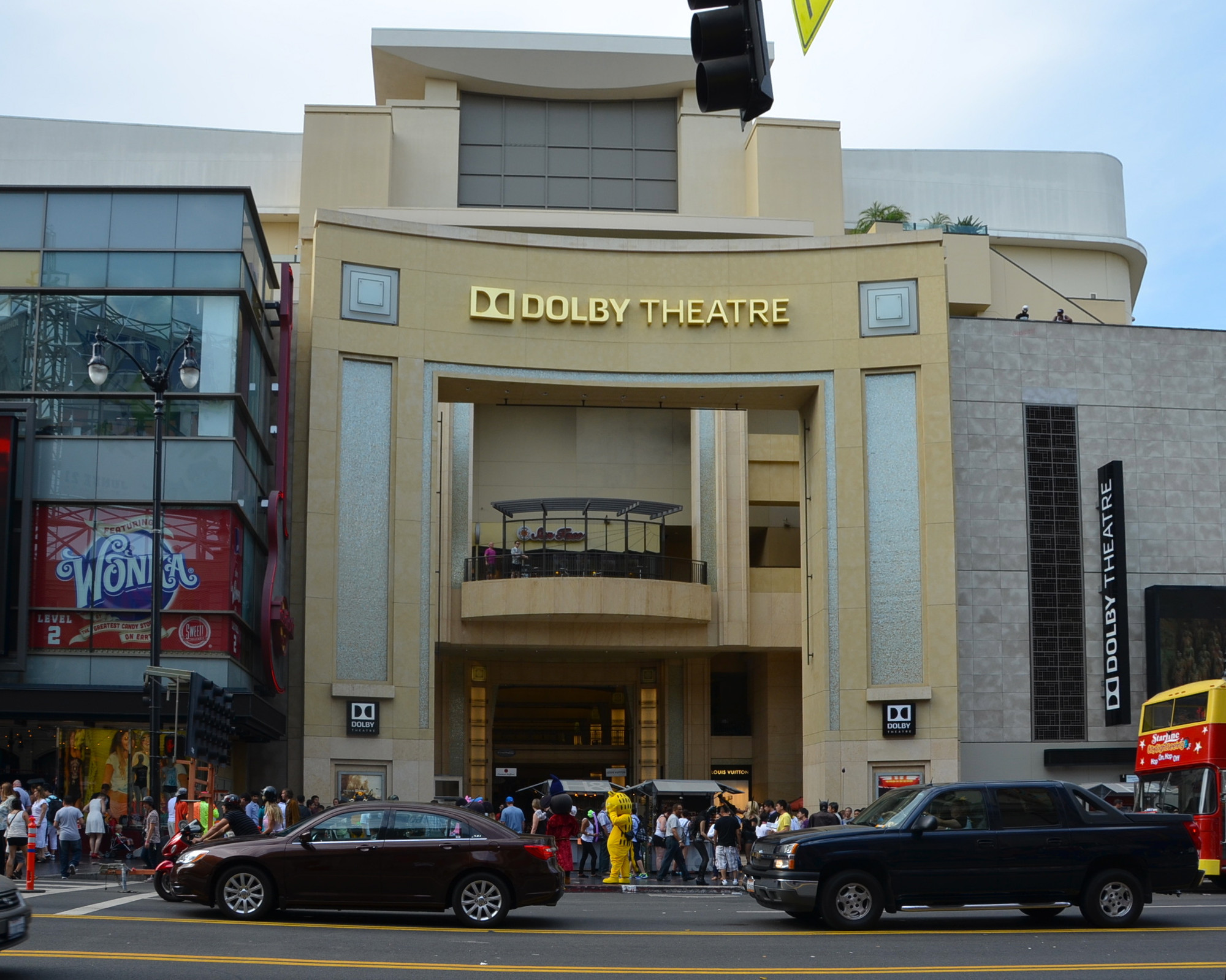 The exterior of the Dolby Theatre in Hollywood at night with Oscars signage and crowds gathered outside