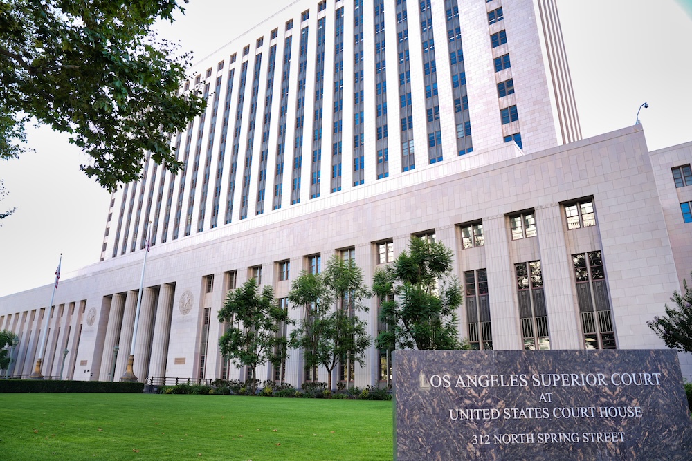 The exterior of the Los Angeles County Superior Court building in daylight with people walking near the entrance.